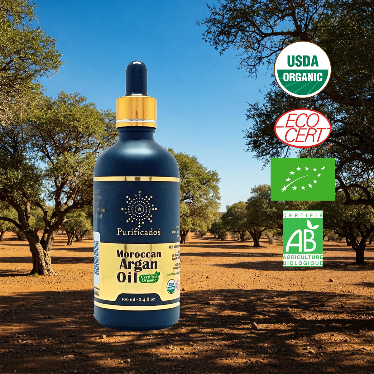 A bottle of Purificados Moroccan Argan Oil with a dropper, displayed in a natural setting with trees in the background. The bottle has a label indicating it is USDA Organic, EcoCert, and AB Organic certified.